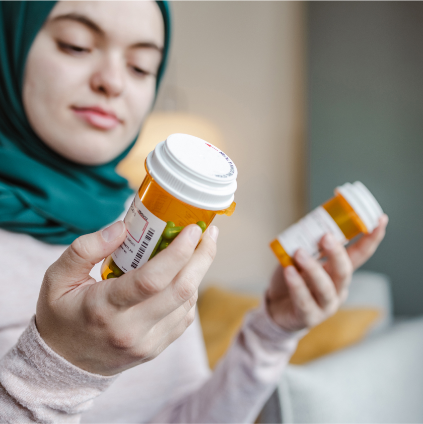 Sniffle Benefits: Woman looking at prescription bottles